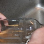 Using hot water, then cold, over the score line to separate the bottle.